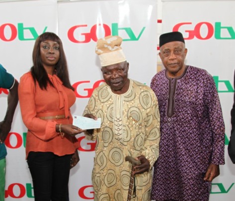 L-R: Efe Obiomah, Public Relations Manager, GOtv presenting a cheque (twenty-five per cent of the total ticket sales for the 3rd GOtv Boxing Night) to Ex-boxer, Dele Jonathan while Dr. Godwin Kanu, President of the NBB of C looks on held at National Stadium Surulere, Lagos today Tuesday 4th of August, 2015.